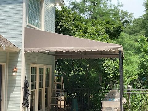A wooden deck with a couch and table under an umbrella
