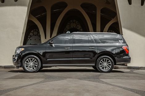 A black suv is parked in front of a building.