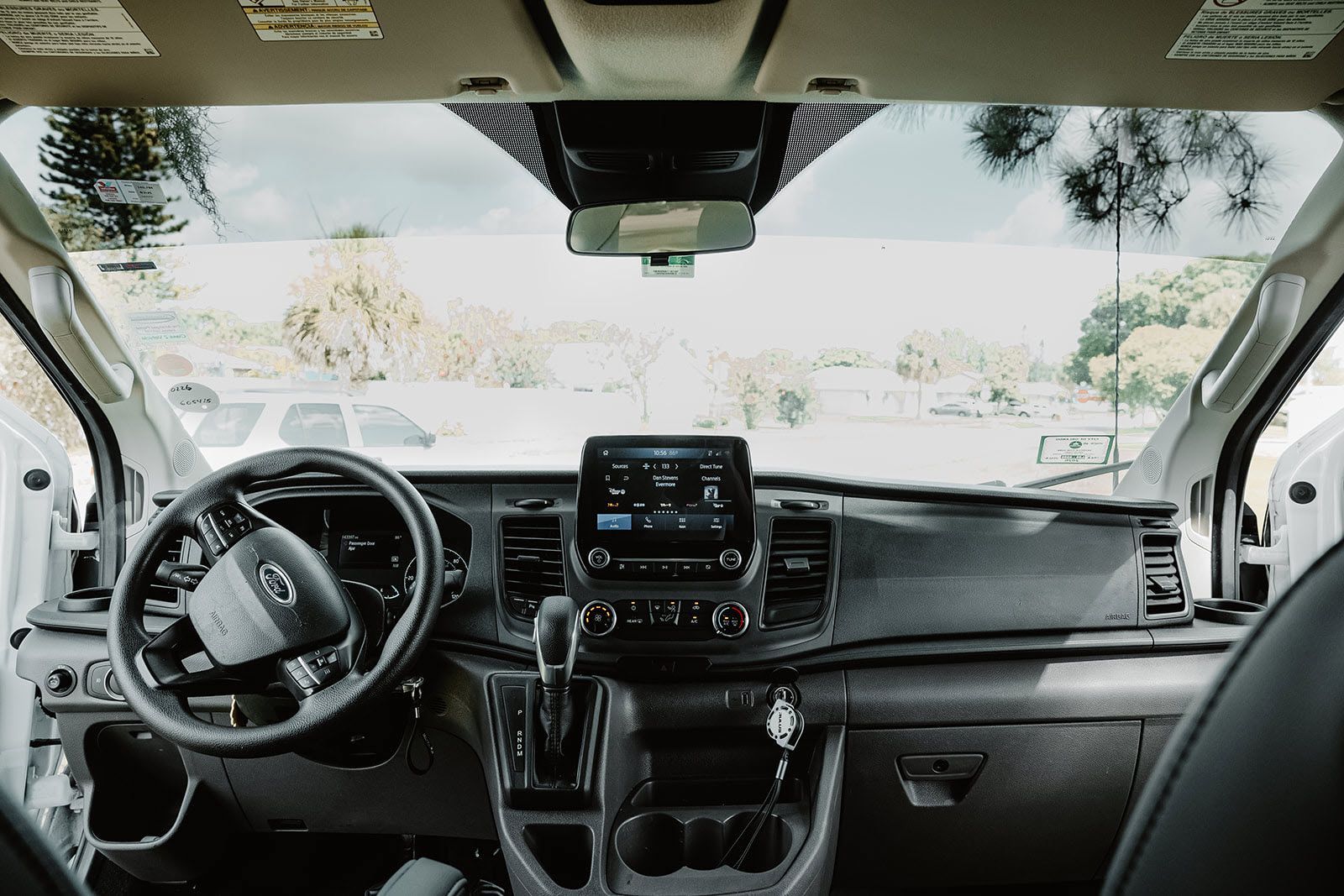 The interior of a white van with a steering wheel and dashboard.