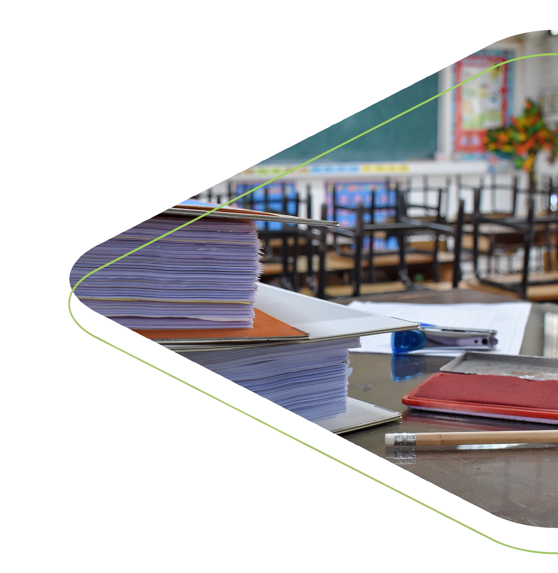 A pile of school work sitting on a desk in a classroom