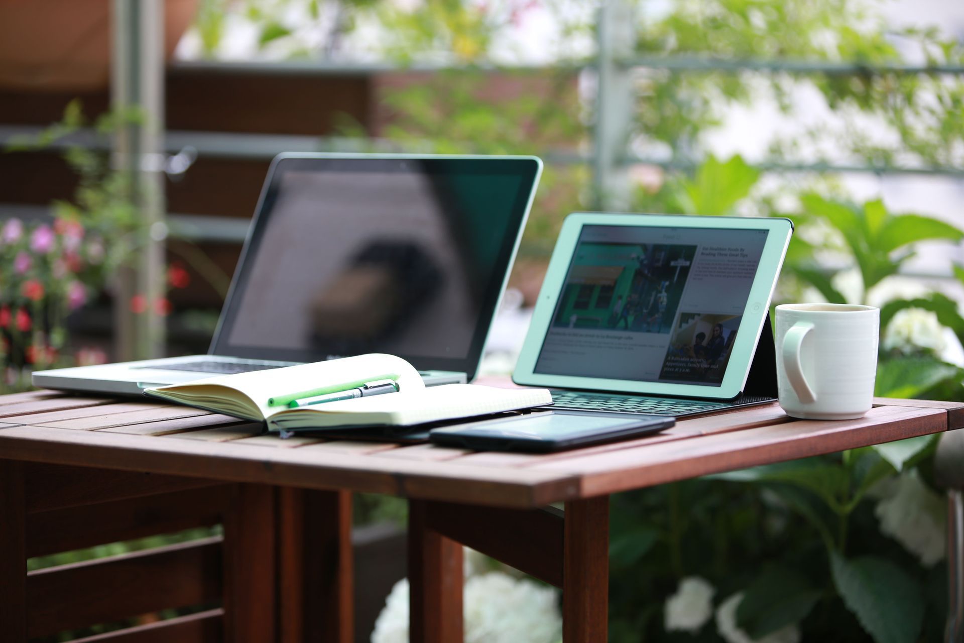 Laptop and notebook on an outdoor table