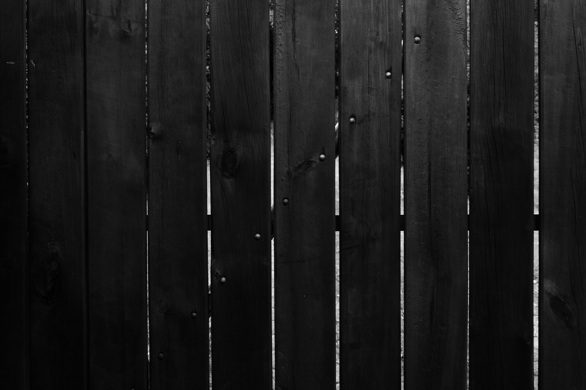 Dark slatted fence panels between posts