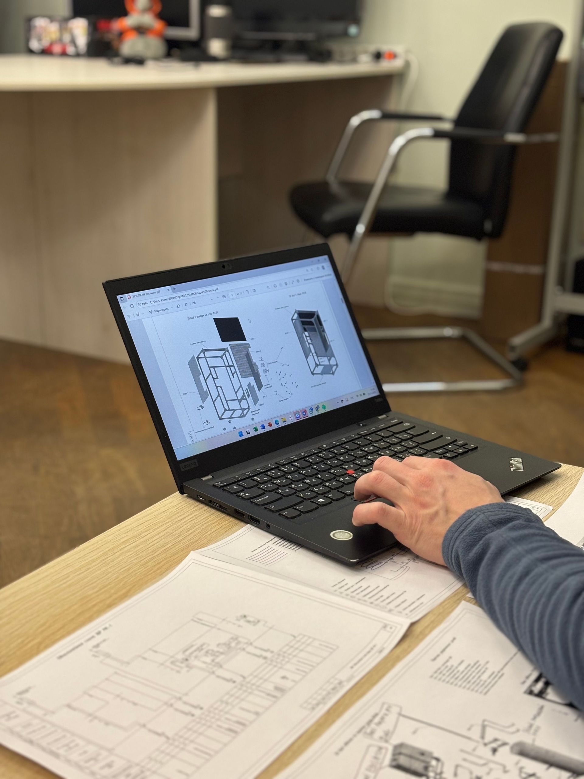 Designer reviewing a 3D CAD model of a part on a laptop