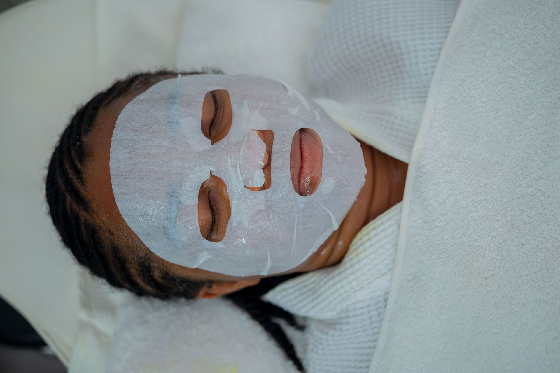 Client relaxing with a sheet mask during a facial