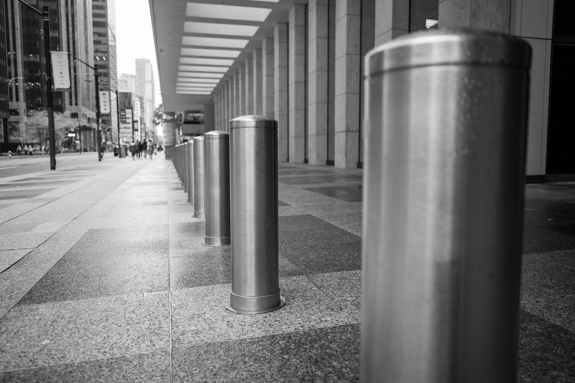 Row of stainless steel bollards at a building entrance