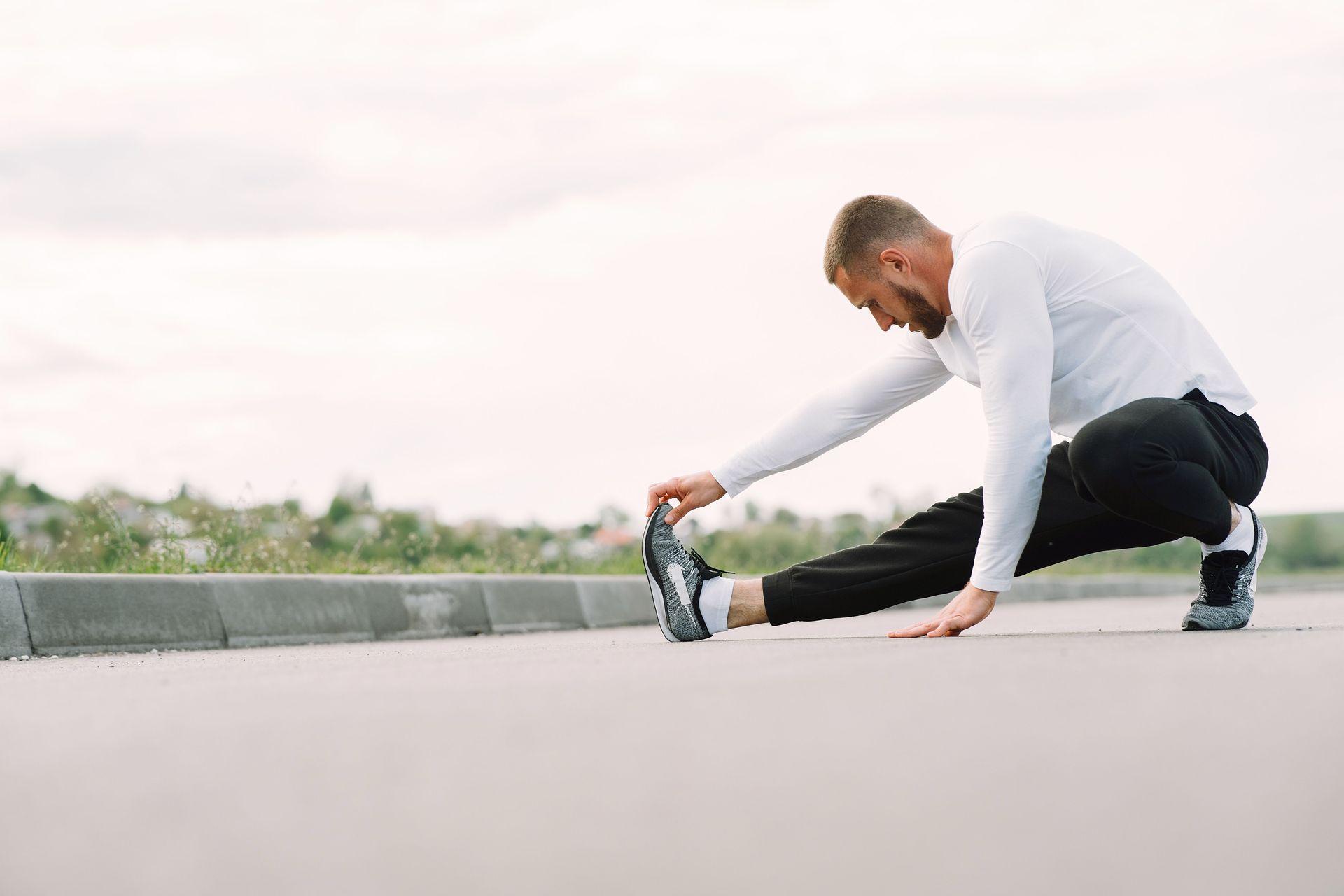 Runner stretching his hamstrings before a run