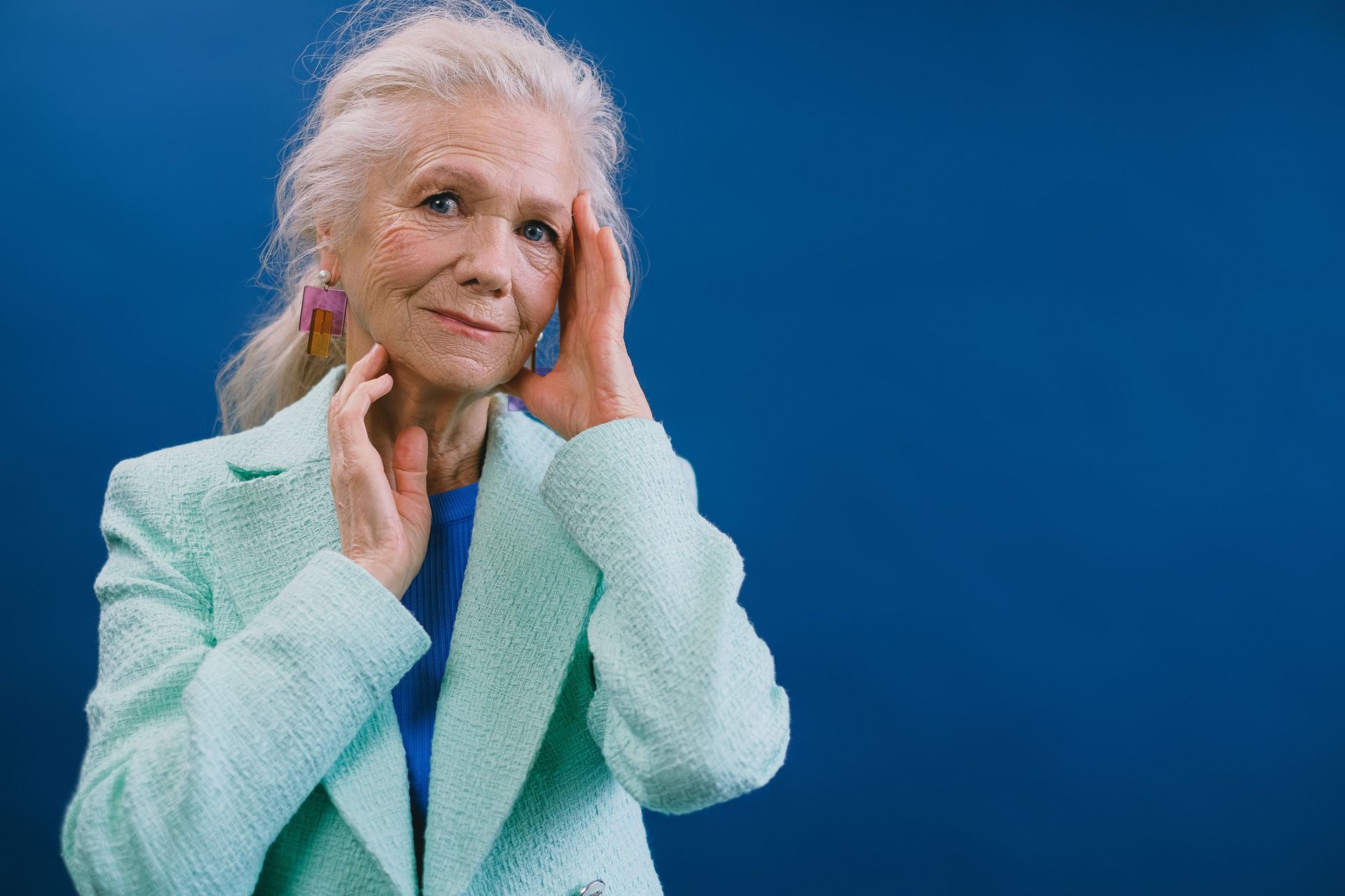 Older woman holding her hands to her ears