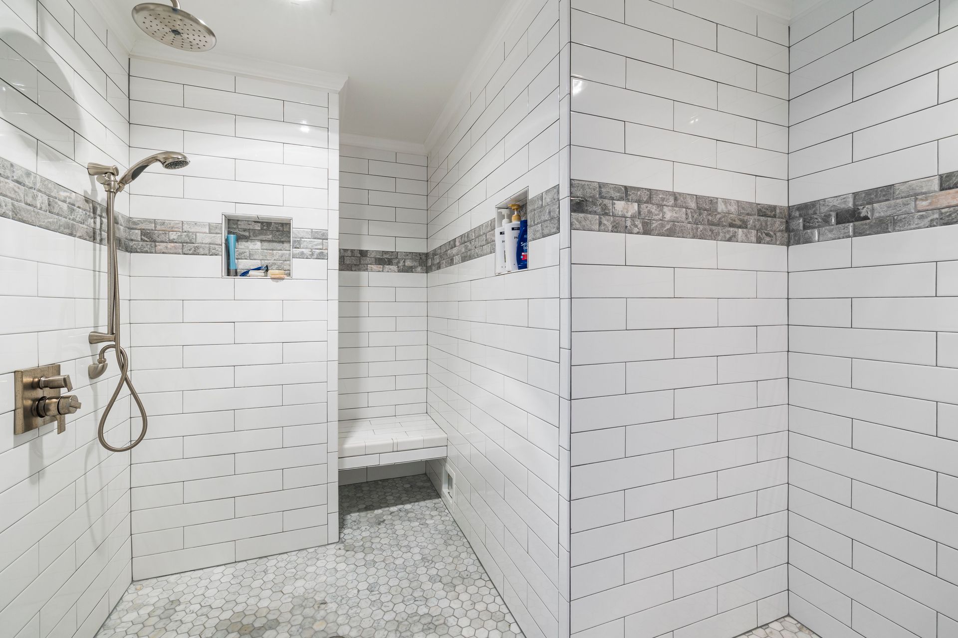 Level-access walk-in shower with white tiles and a built-in bench