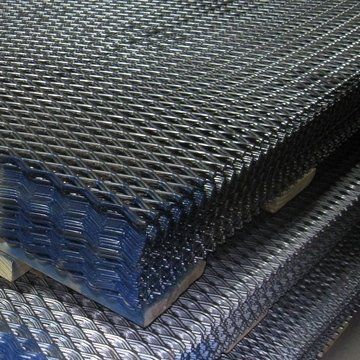 Stacked dark blue metal mesh sheets on a pallet