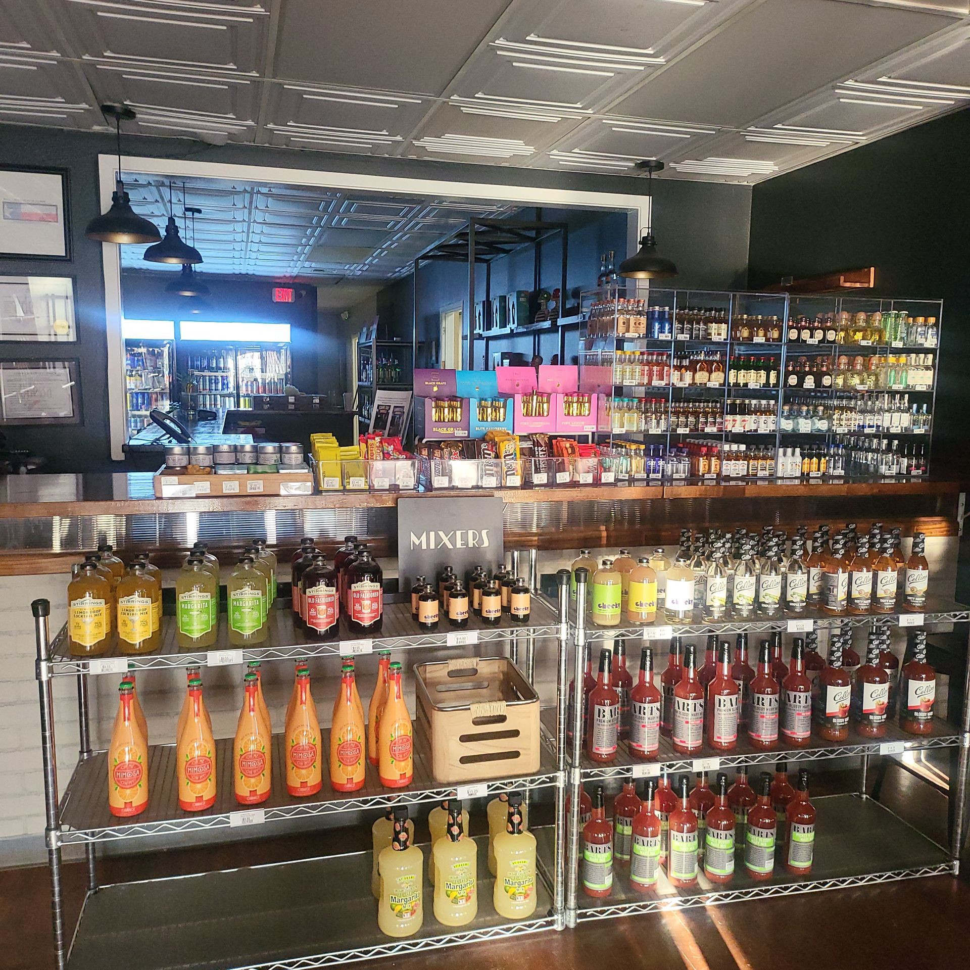 Liquor store interior with shelves of colorful bottles and wine displays under bright ceiling lights