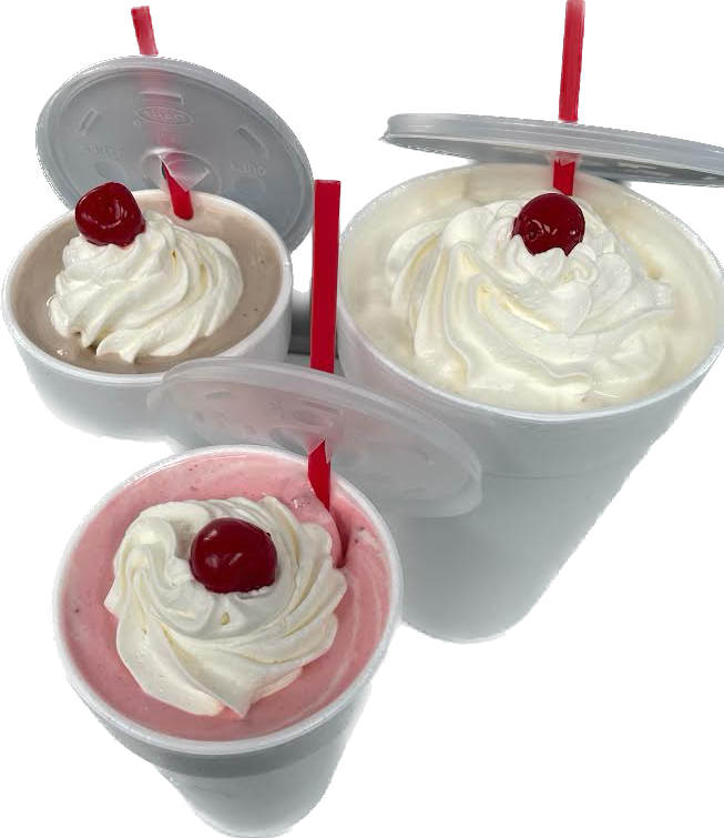 Three milkshakes topped with whipped cream, cherries, and red straws in plastic cups.