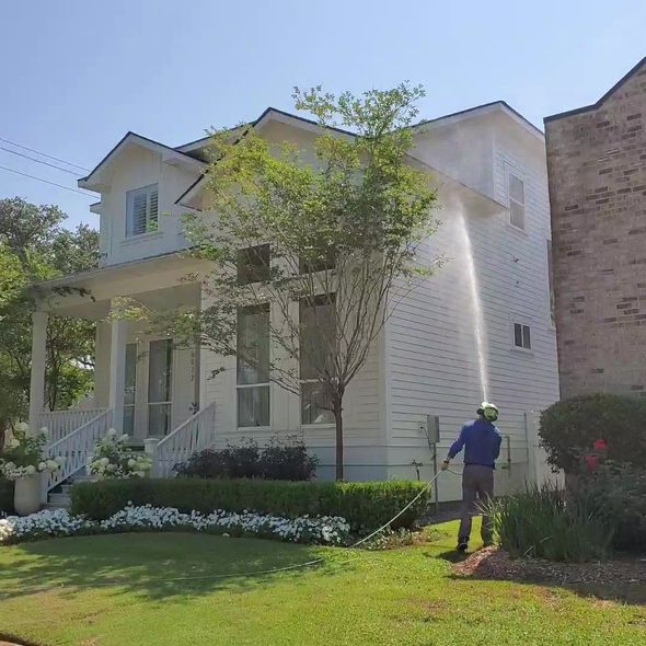 Pressure washer cleaning a wooden deck, with water spraying across the boards