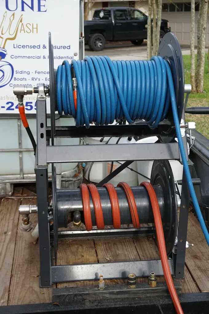 Two hose reels loaded with blue and orange hoses on a utility trailer
