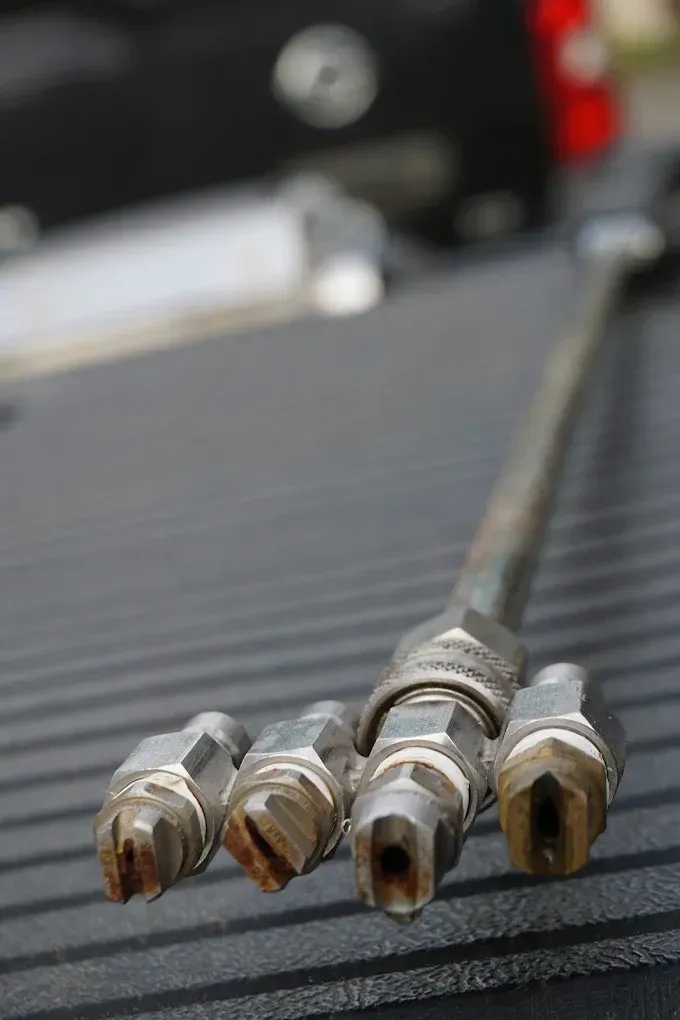 Close-up of four metal cable connectors on a ribbed black surface