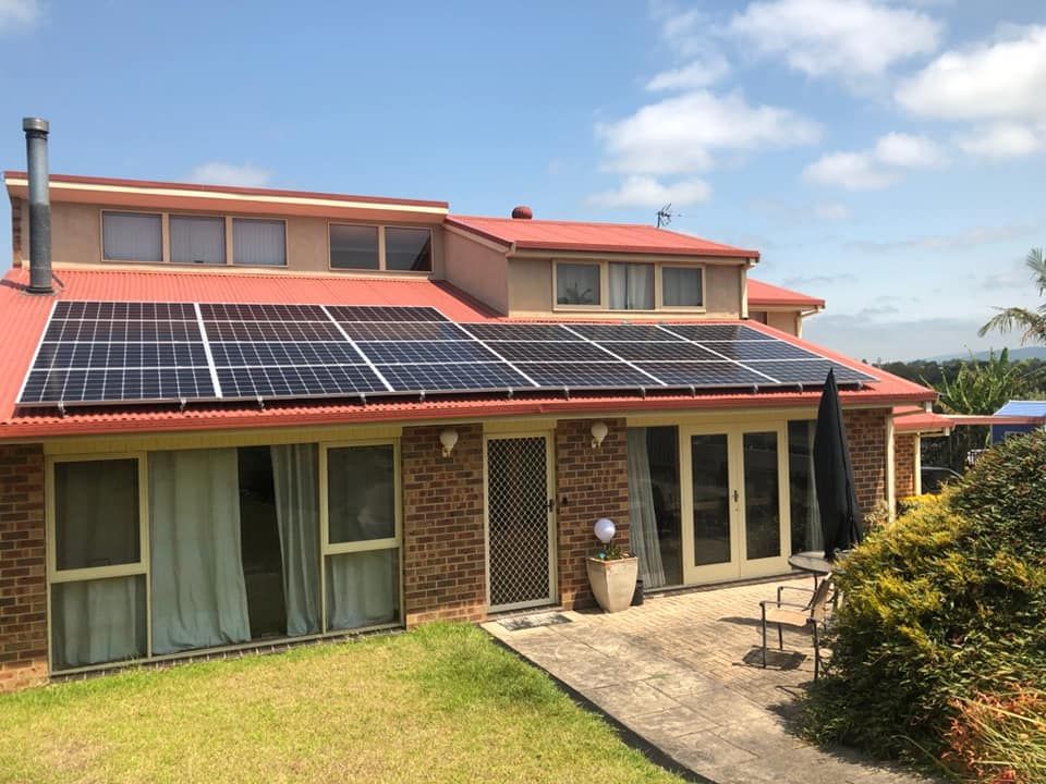A Large Brick House With Solar Panels on the Roof — Spot On Solar International in Newcastle, NSW