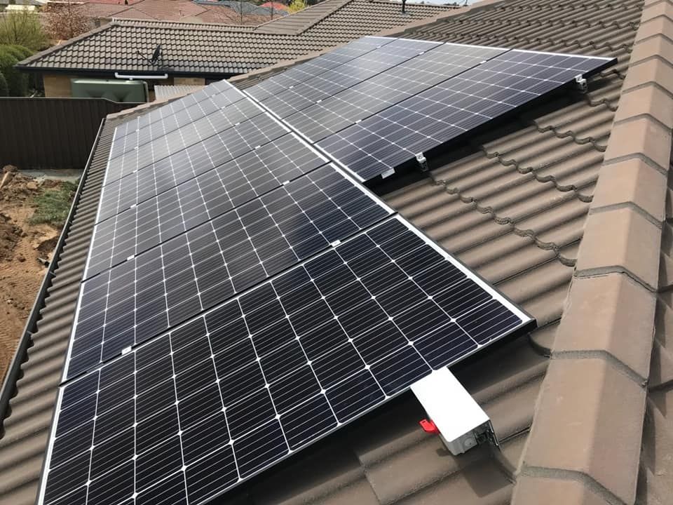 Two Solar Panels Are Sitting on Top of a Tiled Roof — Spot On Solar International in Cessnock, NSW