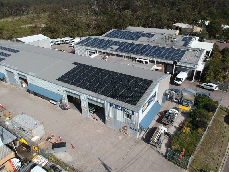 An Aerial View of a Building With Solar Panels on the Roof — Spot On Solar International in Port Stephens, NSW