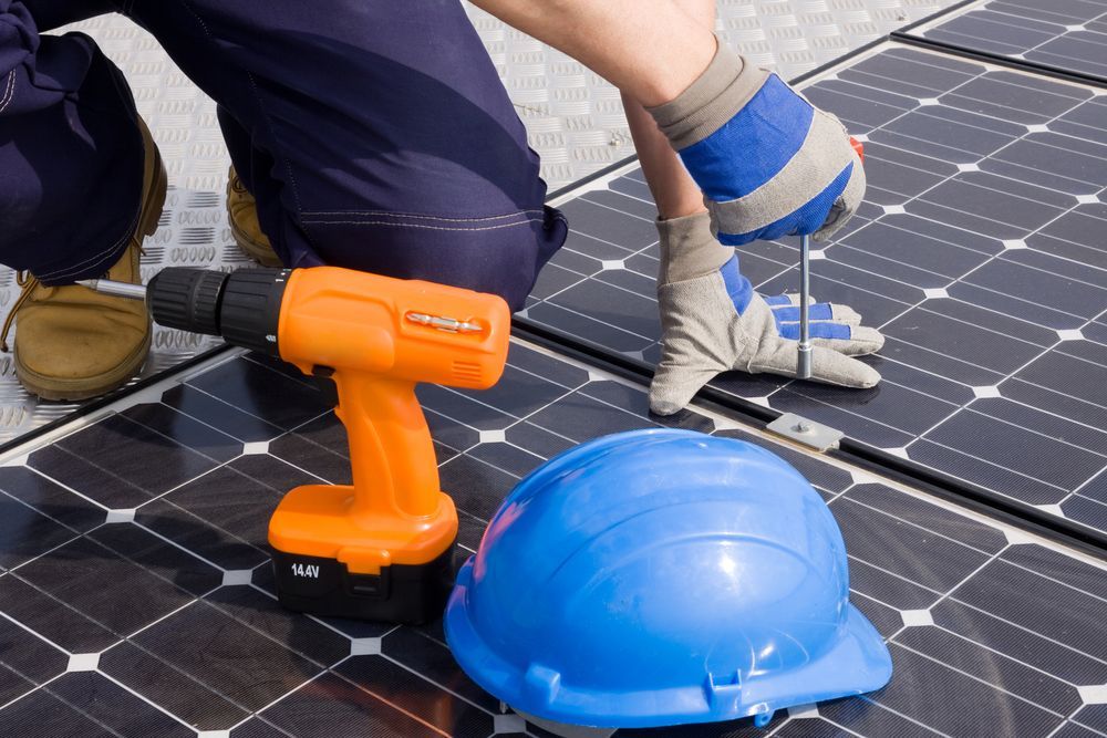 A Person is Working on a Solar Panel With a Drill and a Hard Hat — Spot On Solar International in Beresfield, NSW
