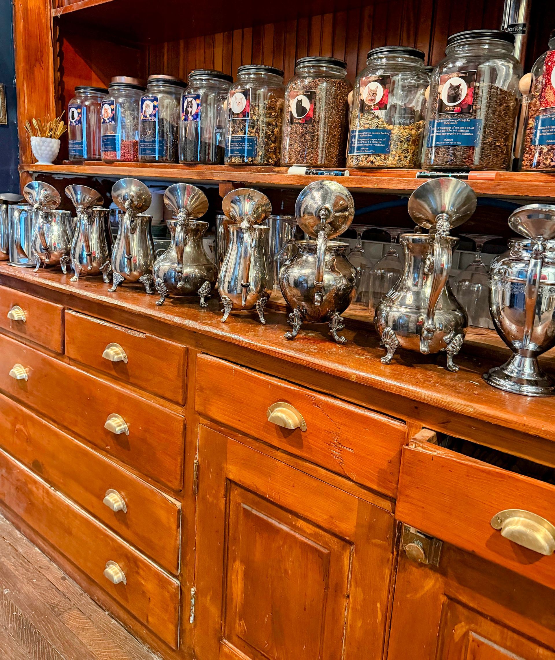 Glass and silver trophy cups lined on a wooden cabinet in a display room
