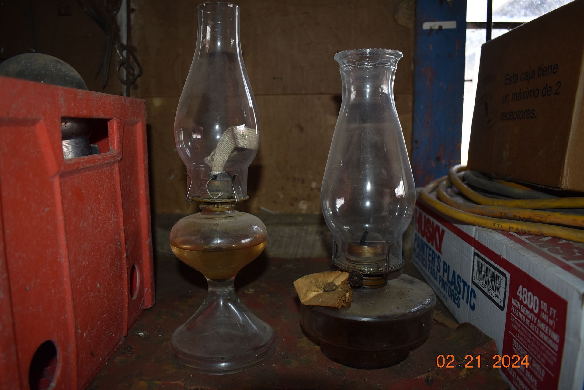 two oil lamps are sitting on a wooden table .