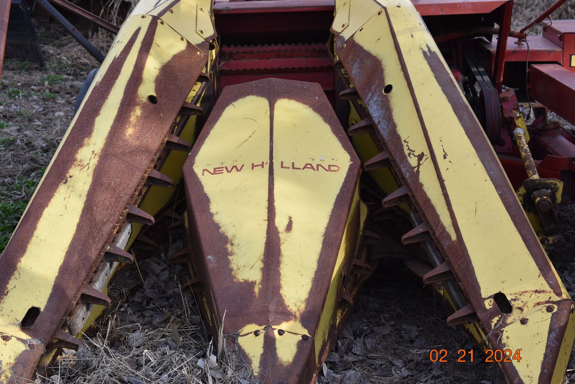 a rusty new holland tractor sits in a field