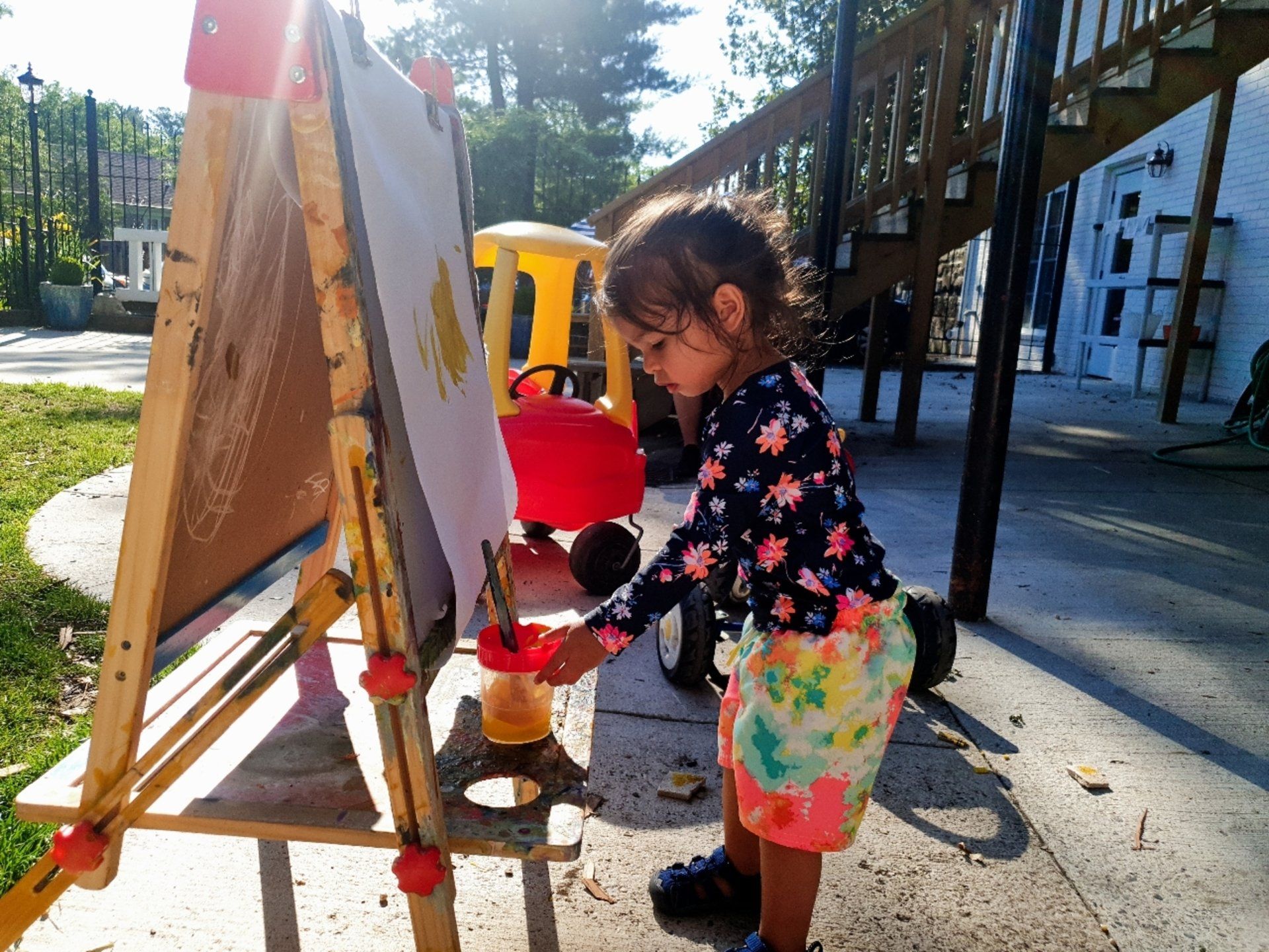 Montessori child painting outdoors