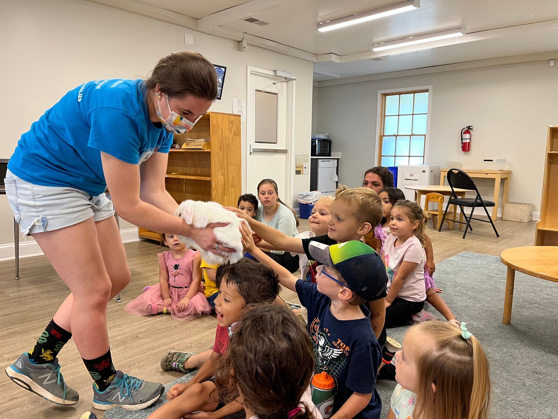 Montessori children petting a rabbit