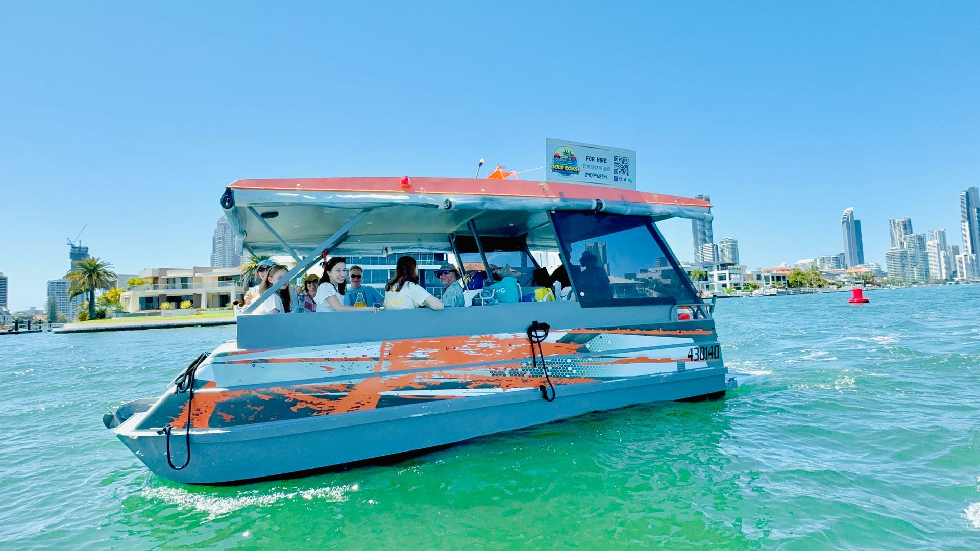 A boat with people on it is floating on top of a body of water.
