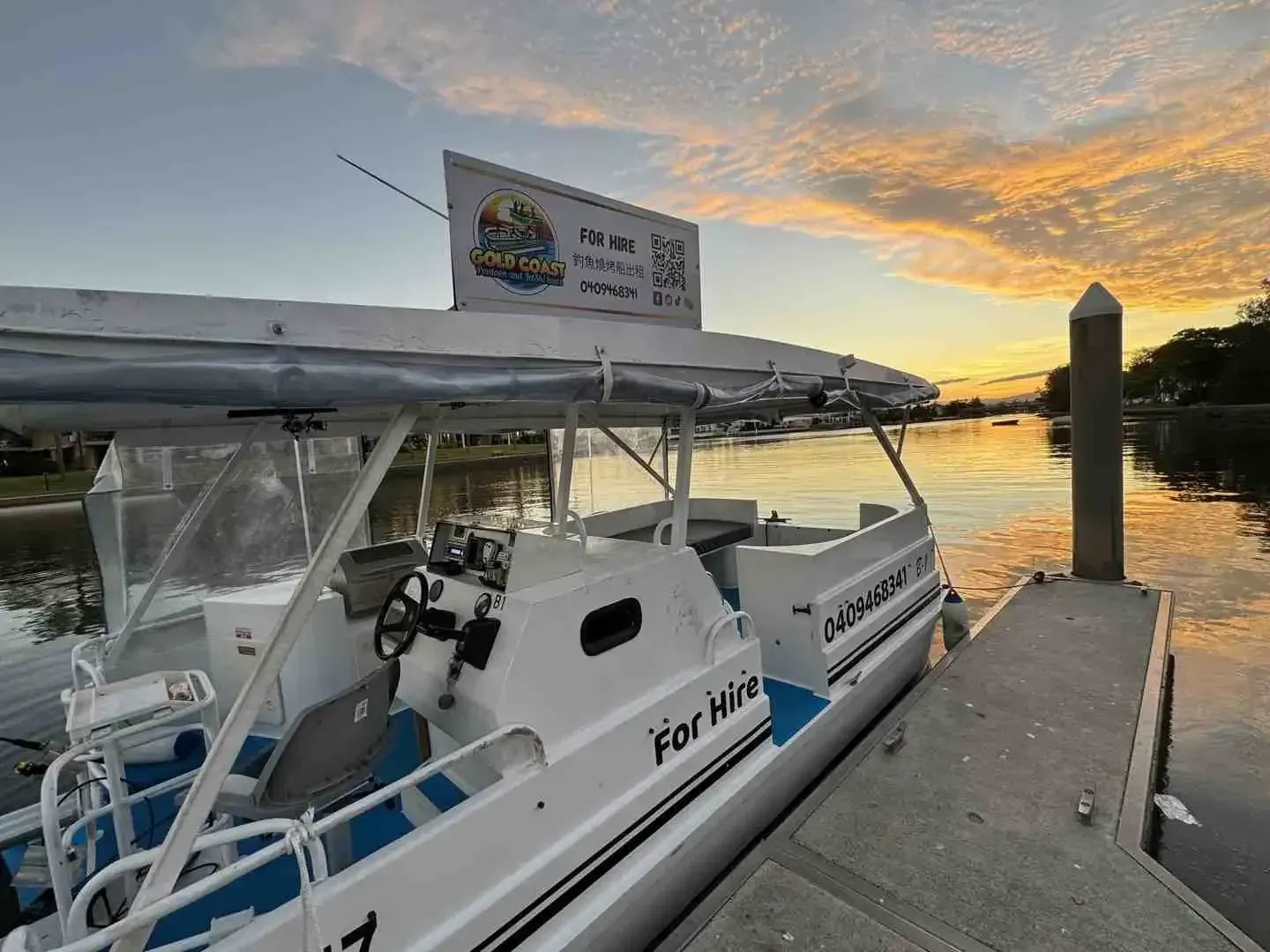 Boat docked at a pier at sunset; features 