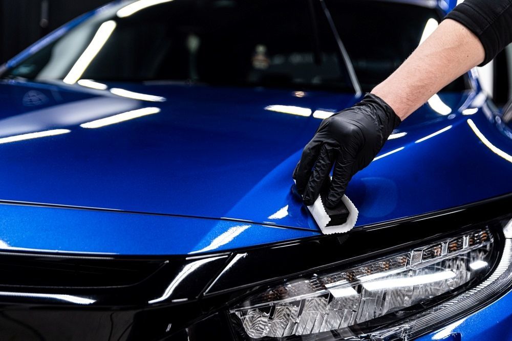 Technician applying ceramic coating to car paint in Cairns.