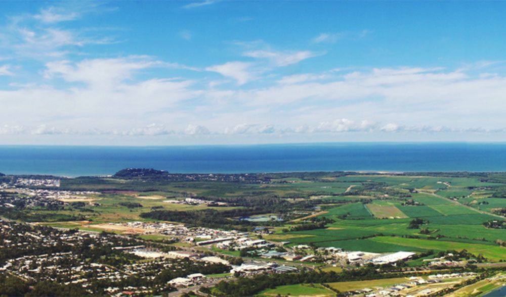 An Aerial View Of A City Surrounded By Fields And A Body Of Water — Jay's Tint in Smithfield, QLD