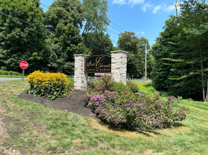A sign is in the middle of a lush green field