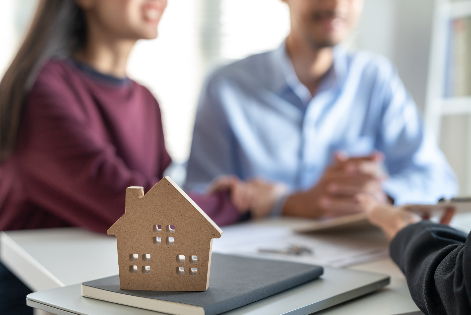 A man is giving a woman a model house and money.