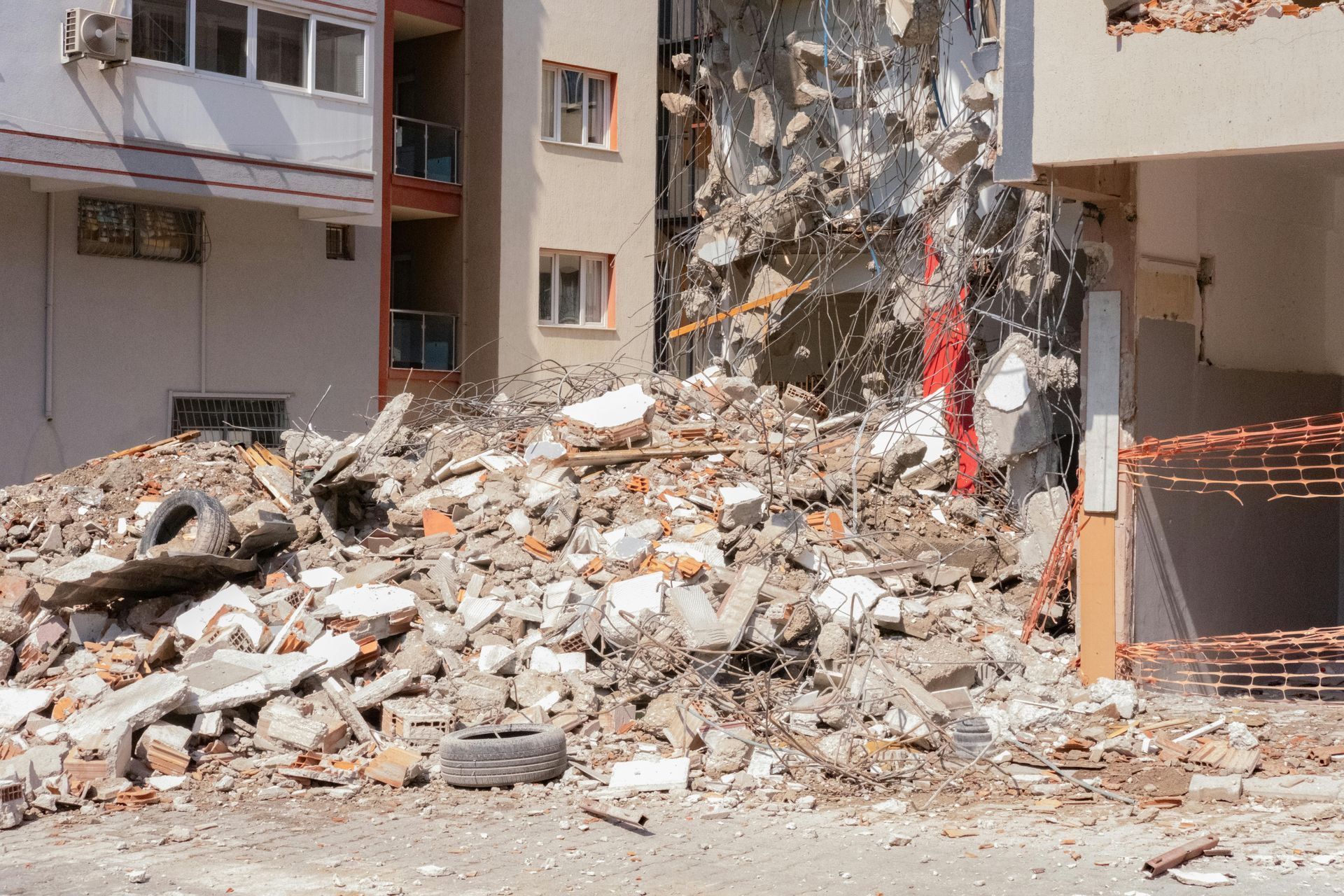 A large pile of concrete rubble and debris from a partially demolished residential building structure.