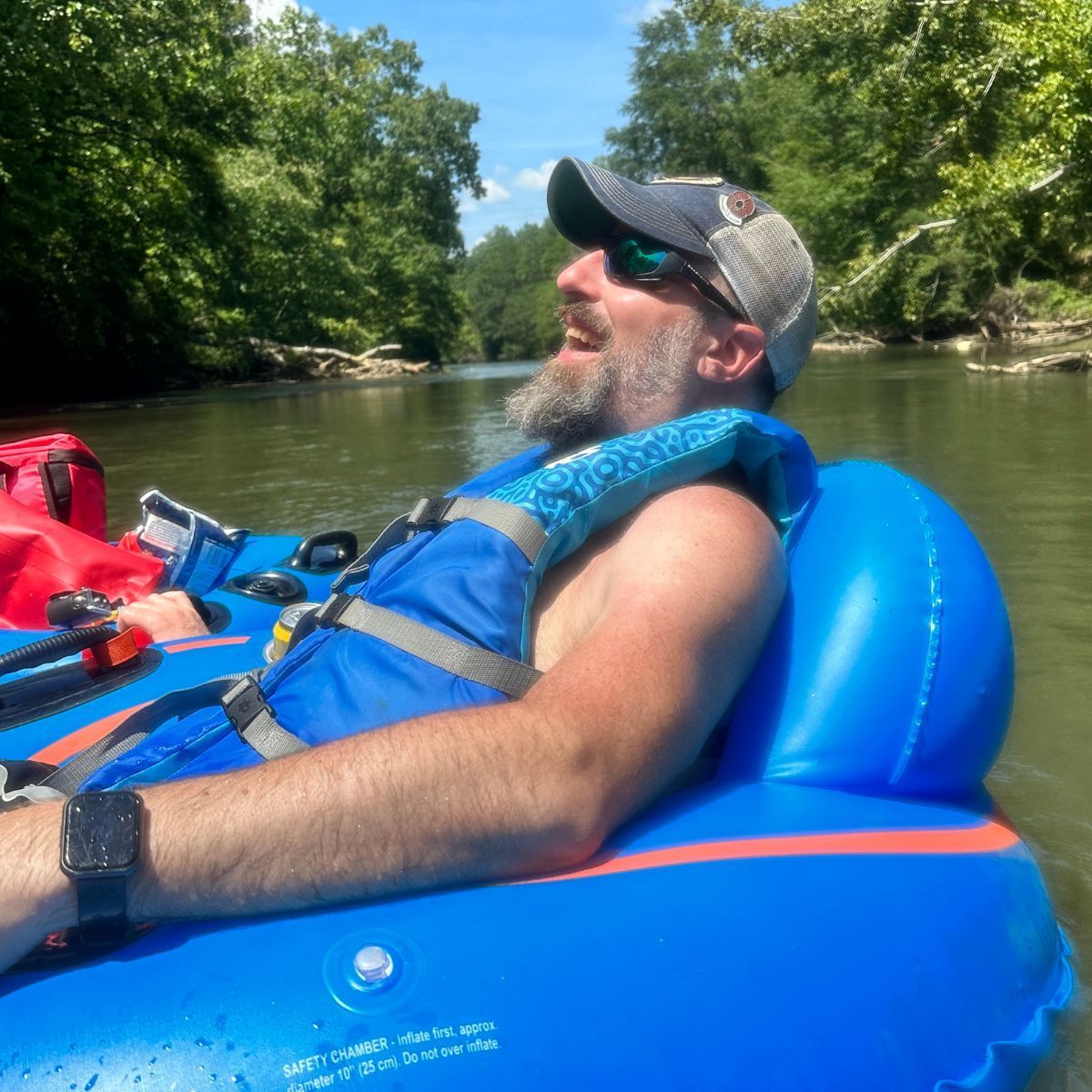 Man relaxing in a blue inflatable tube on a the Saluda river