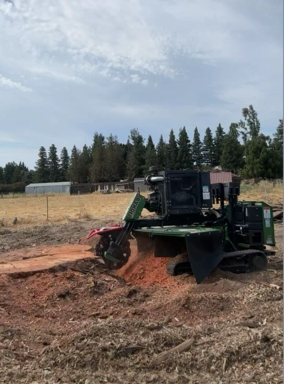 A machine is cutting a tree stump in half.