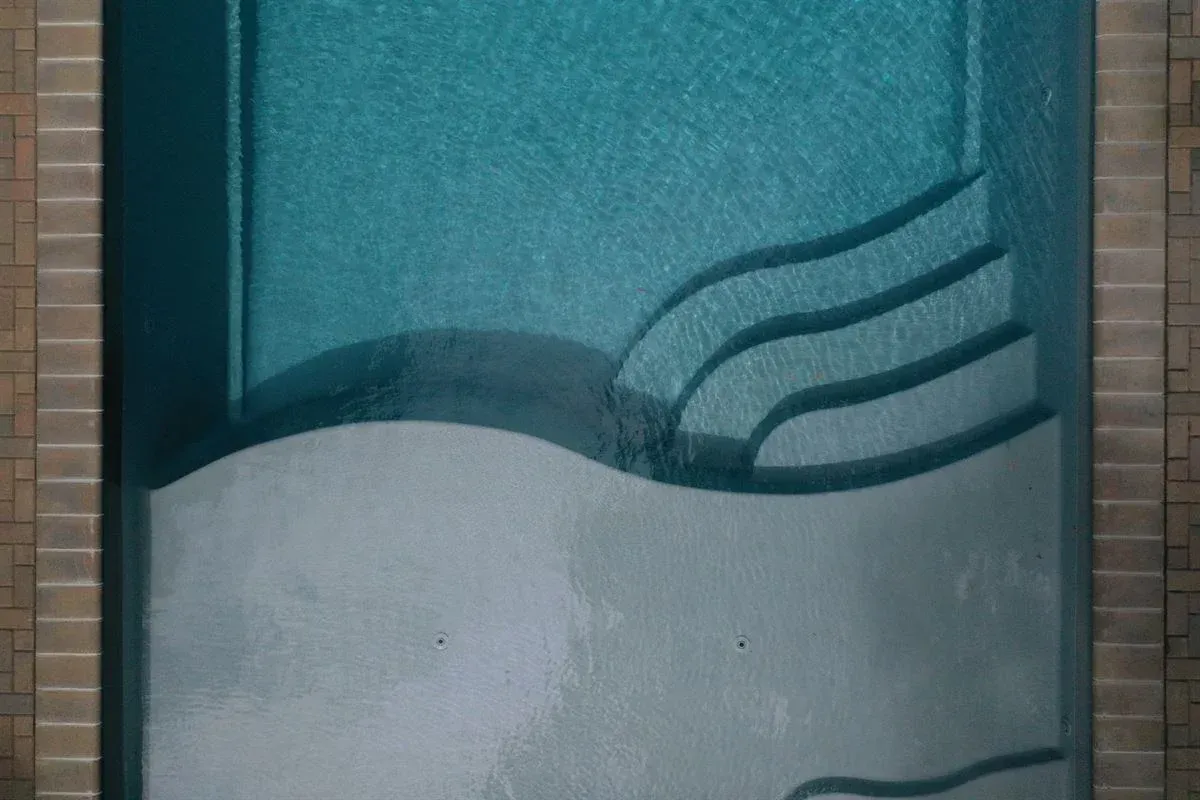 Blue-gray abstract mural with wavy white band and three curved lines on a wall