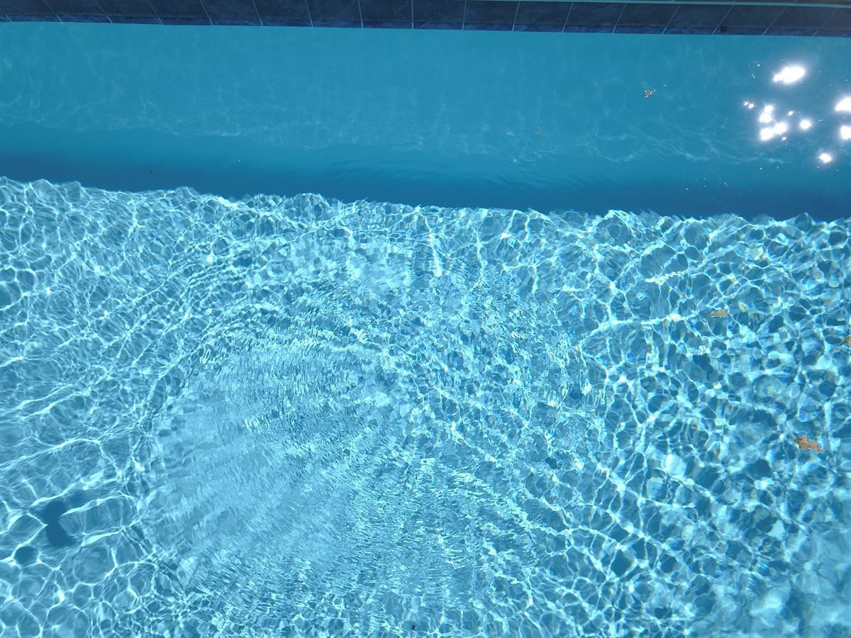 Blue swimming pool water with rippling sunlight reflections