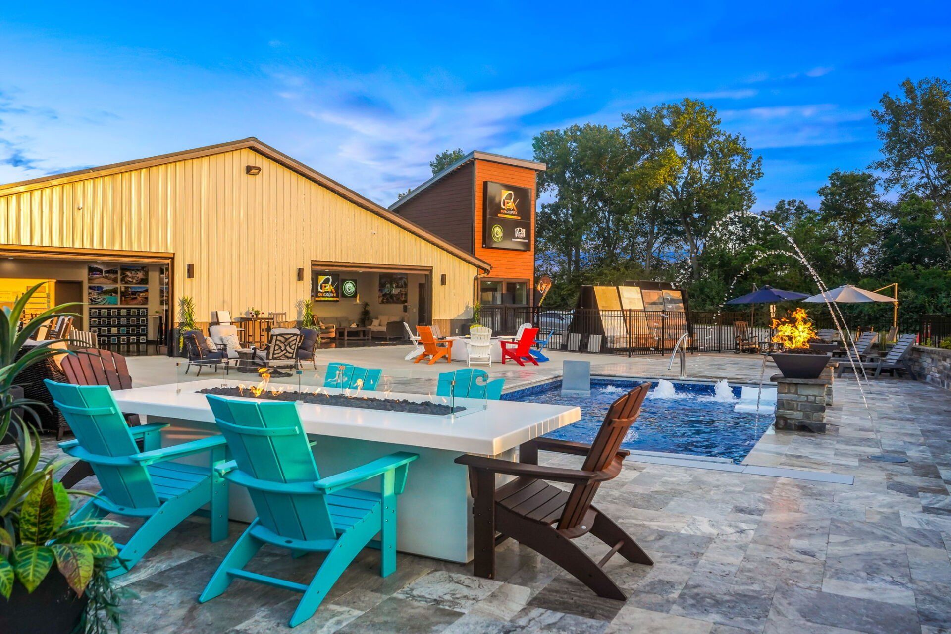 Outdoor patio with turquoise chairs, a pool, and a yellow restaurant building under a blue sky