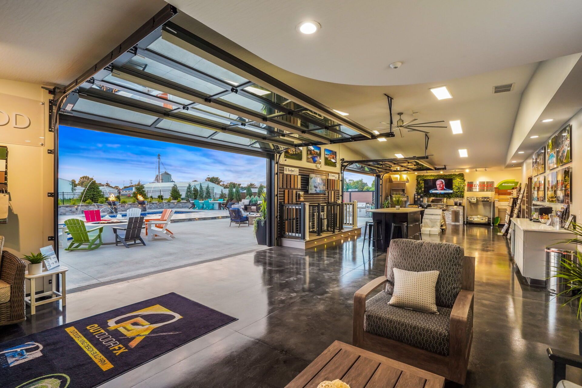 Modern hotel lobby with open garage-style entrance, seating area, and a view of the parking lot outside