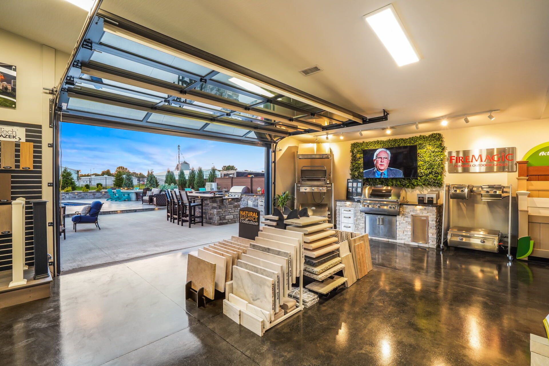 Garage interior with open door, stacked materials, and a TV on the wall.