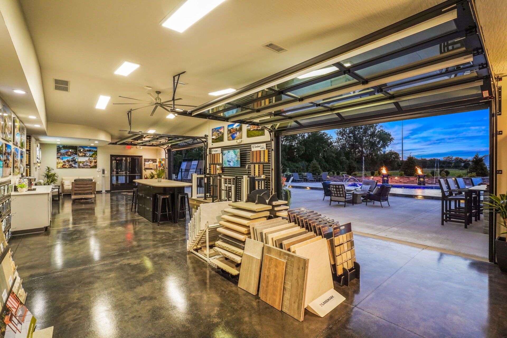 Lumberyard interior with stacked wood near an open garage door at dusk