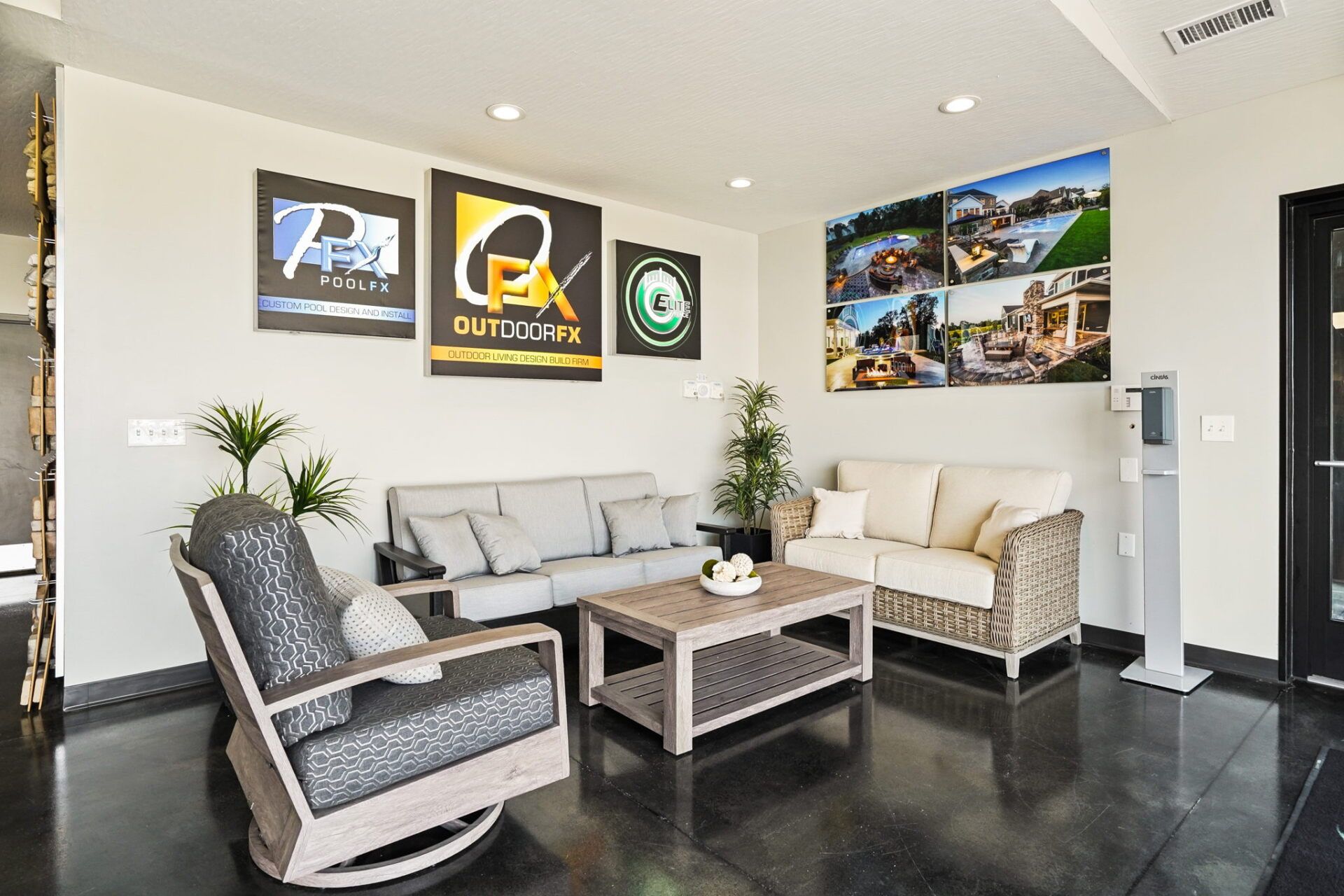 Modern office waiting area with gray and beige chairs, coffee table, and wall art on white walls