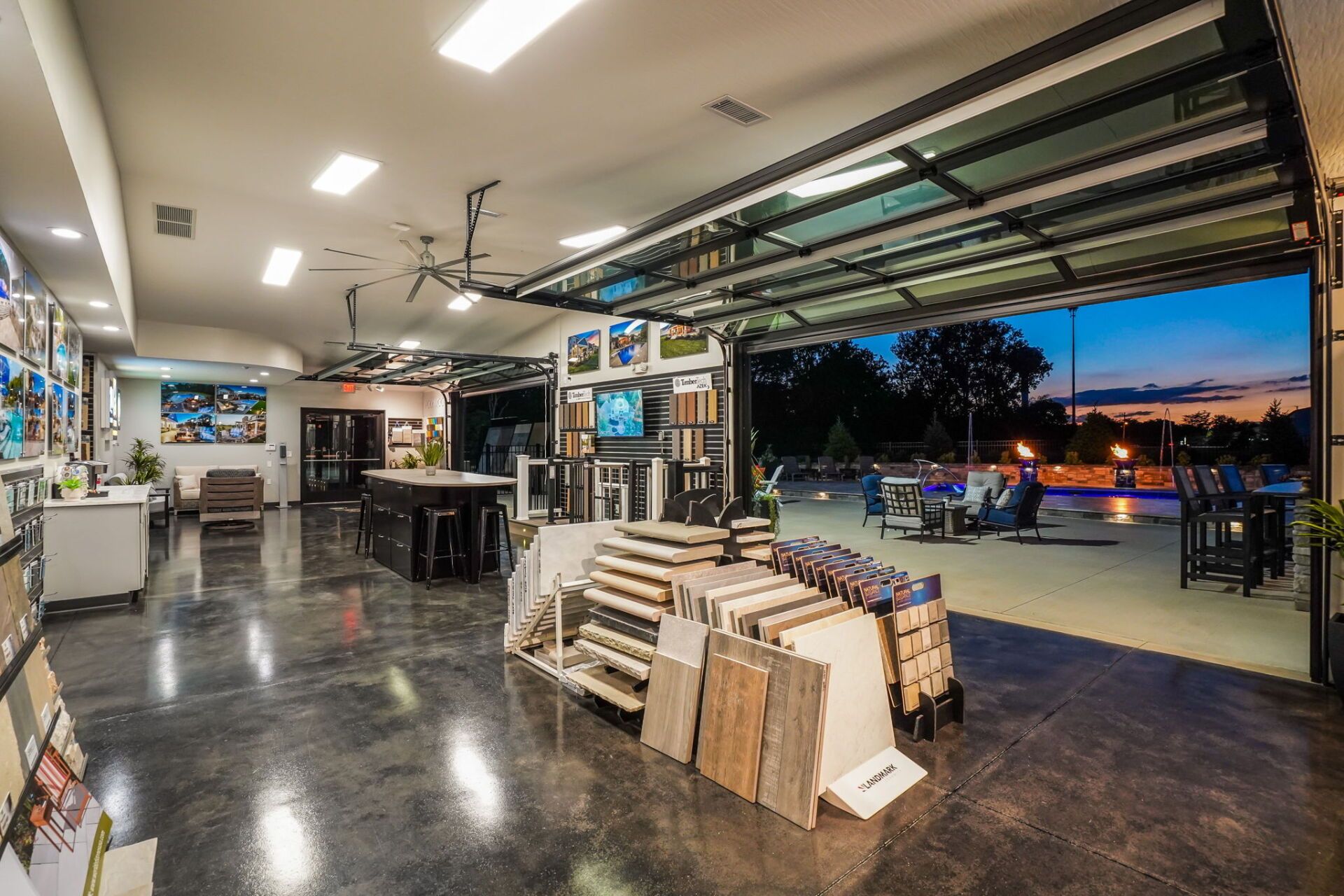 Open-air retail space at dusk with stacked wood displays and a view of the street outside