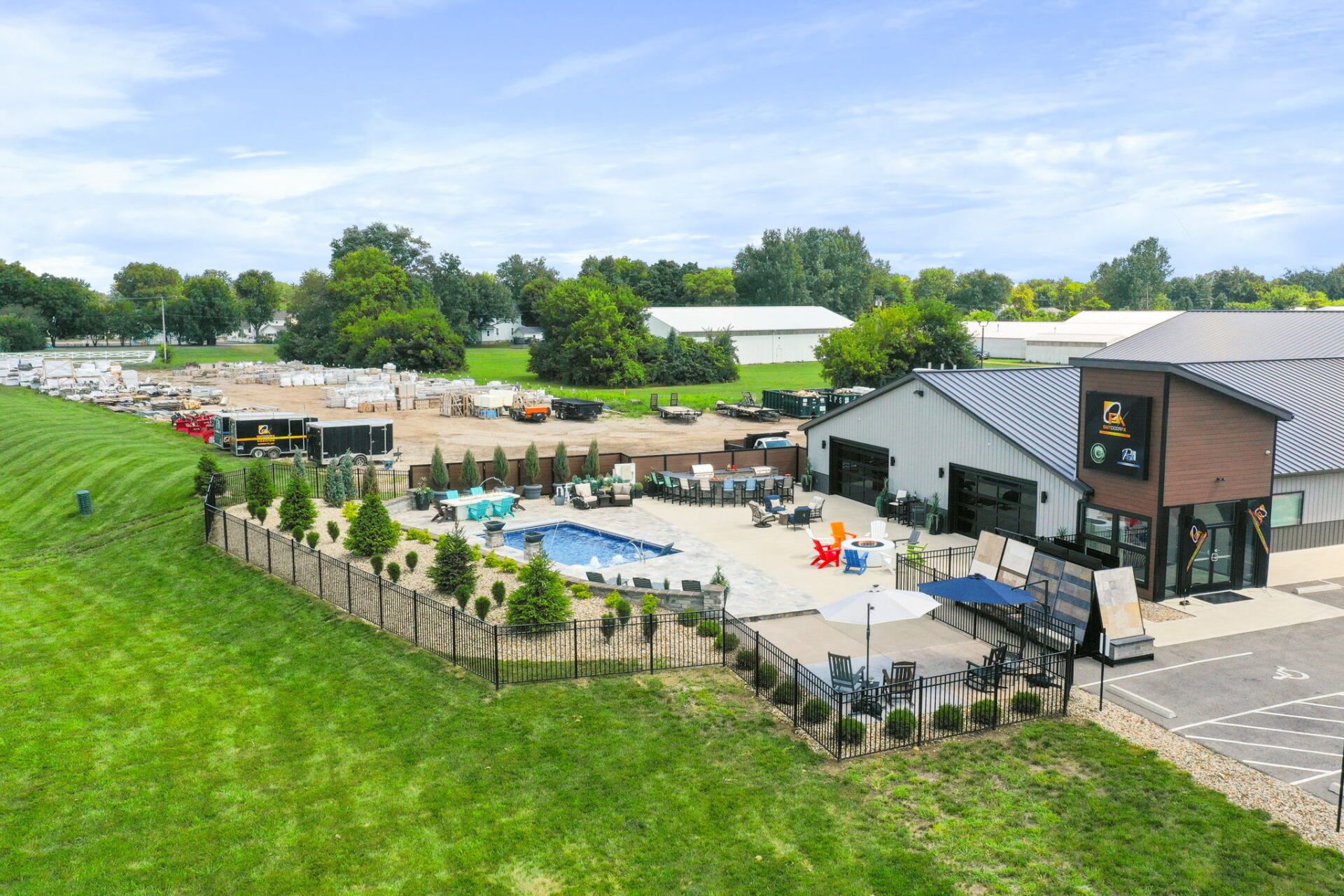 Aerial view of a farm café patio, outdoor seating, and green fields under a cloudy sky