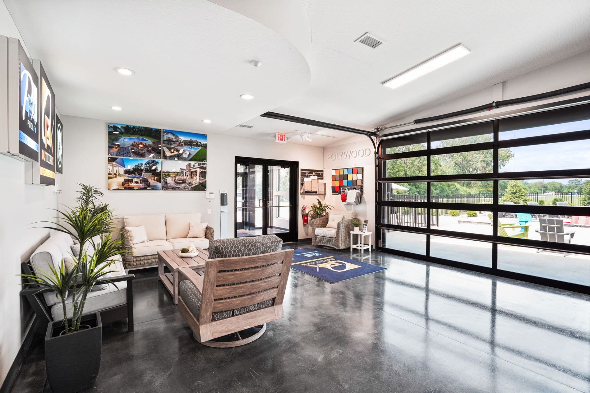 Modern office lobby with seating, plants, wall art, and a glass garage-style door
