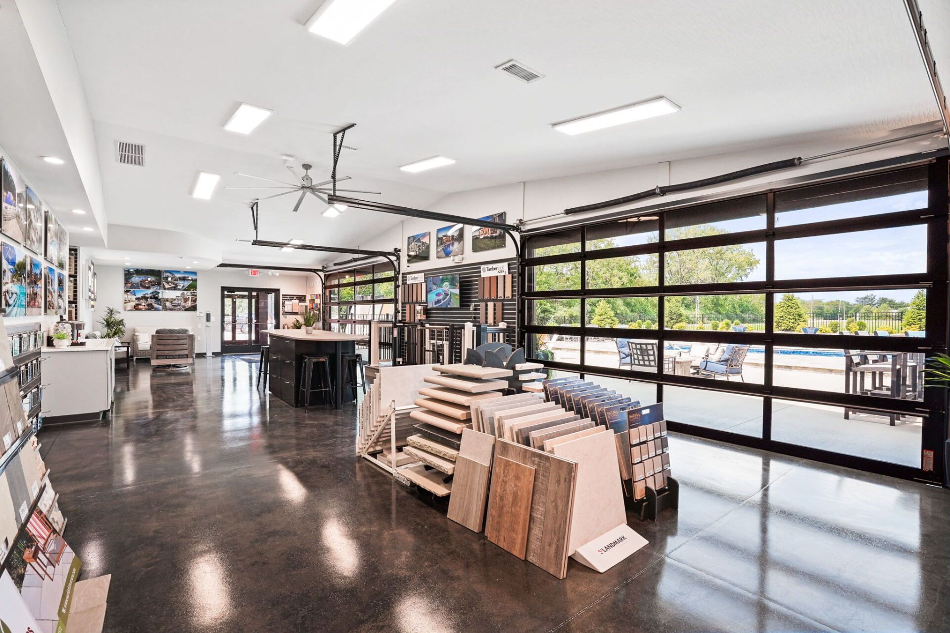 Bright modern showroom with display racks, polished floors, and large garage-style windows