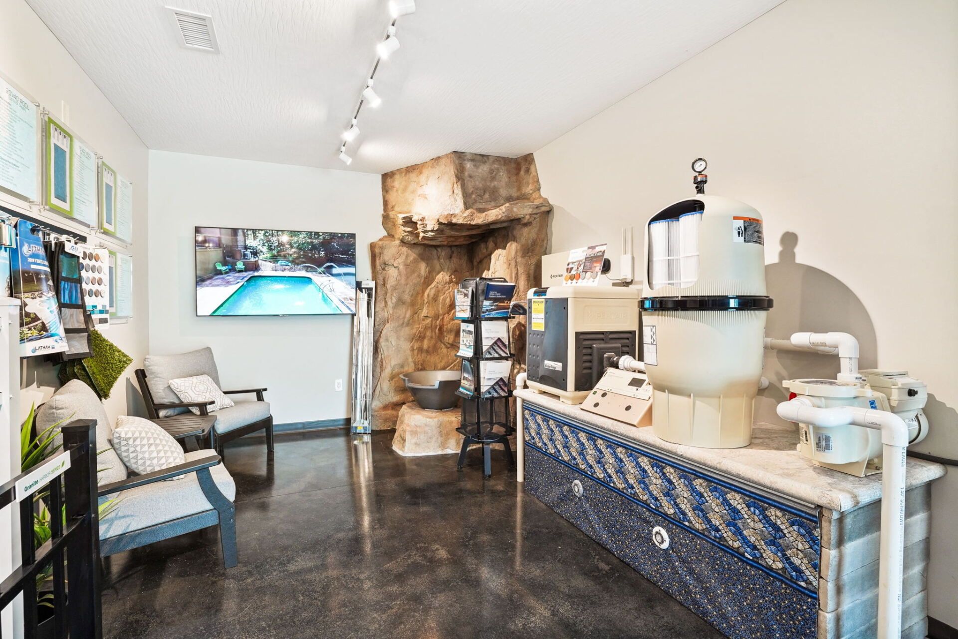 Bright spa reception with white walls, black floor, lounge chairs, and a coffee counter with drinks dispenser