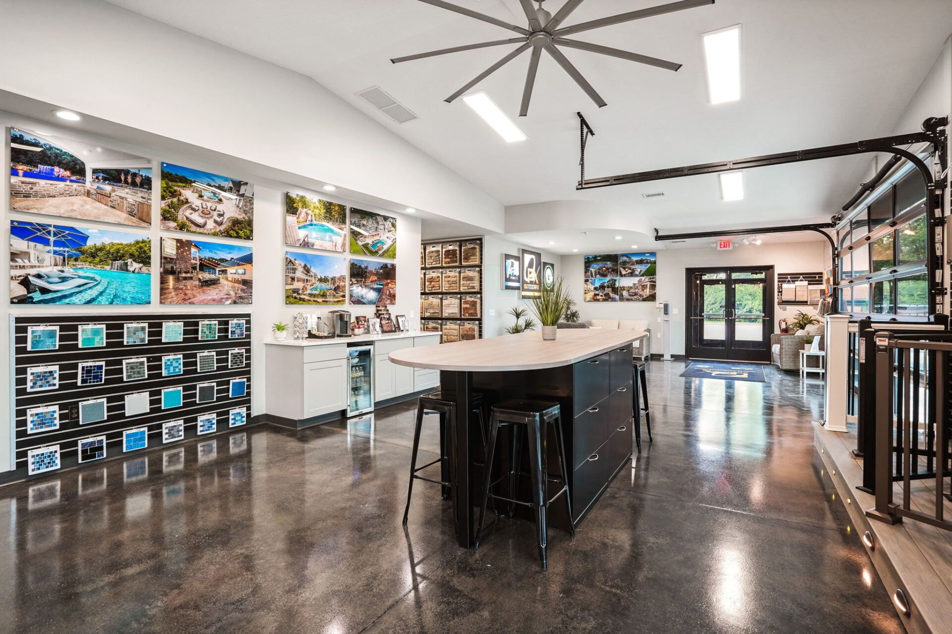 Modern showroom with sample displays, white tables, and polished concrete floor