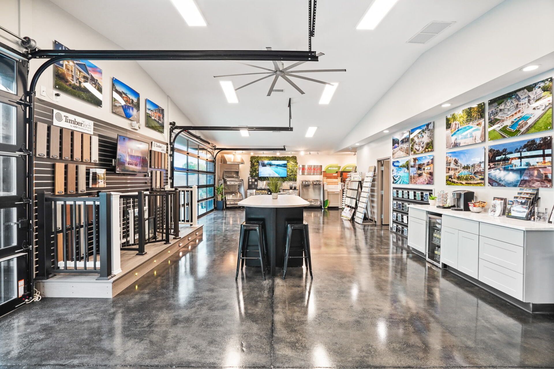 Modern showroom interior with flooring displays, wall samples, and large landscape photos under bright lights